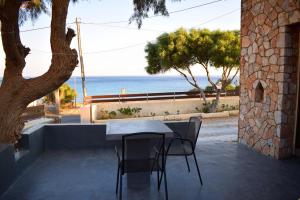 una mesa y sillas con vistas al océano en Pasithea villas, en Frangokastello