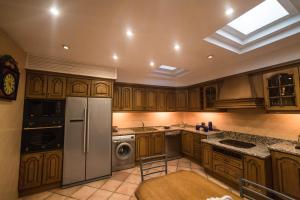 a kitchen with wooden cabinets and stainless steel appliances at Casa en las Termas de Amador de los Ríos in Toledo +25 photos