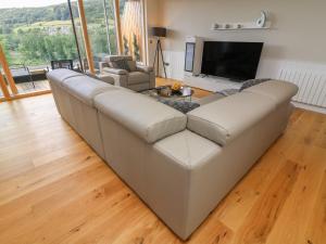 a large white couch in a living room with a television at The Works in Cononley