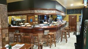 bar w restauracji ze stołami i krzesłami w obiekcie Pensión Bide-Ondo w mieście Amorebieta-Etxano