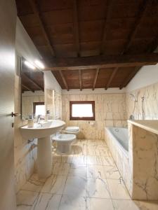 a bathroom with a sink and a toilet and a tub at Villa Broglia House in Verona