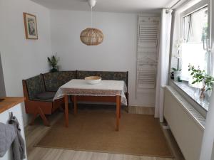 - une salle à manger avec une table et un canapé dans l'établissement Ferienwohnung Lindenhof, zentrumsnah mit Terrasse und Grillmöglichkeit, à Magdebourg