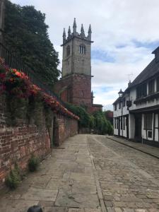 an empty street with a clock tower in the distance at "Wesley House" Historic home in town Centre with Parking in Shrewsbury