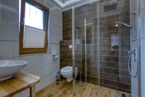 uma casa de banho com um chuveiro, um WC e um lavatório. em Pokoje Gościnne Dawidek em Zakopane
