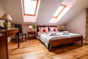a bedroom with a bed and a desk and windows at Eco Friendly Hotel Dália in Košice +28 photos