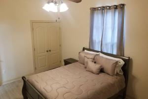 ein Schlafzimmer mit einem Bett mit Kissen und einem Fenster in der Unterkunft Villa 8 in Hammond
