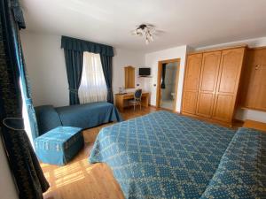 a bedroom with a blue bed and a desk at Villa Golf in Pinzolo