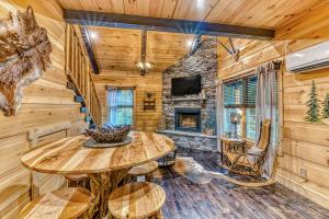 a dining room with a table and a fireplace at Noir Pine Creekside Chalet in Gatlinburg