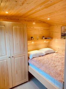 a bedroom with a bed in a wooden cabin at La Casuta din Ciocanesti Exclusive in Ciocăneşti