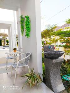 a sink on a patio with a table and a chair at Alysahouse - 2 Bedrooms, Dekat JTP3 in Batu