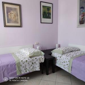 La casa di Antonia في كاتانيا: سريرين يجلسون بجانب بعض في غرفة