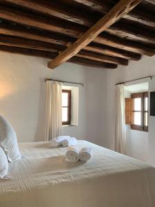 a bedroom with a white bed and white walls at Can Quince de Balafia - Turismo de Interior in Sant Llorenç de Balafia