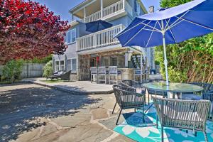 WaterfordにあるDeluxe Waterford Home with Views, Outdoor Bar and Moreのパティオに置かれたテーブルと椅子、そして傘
