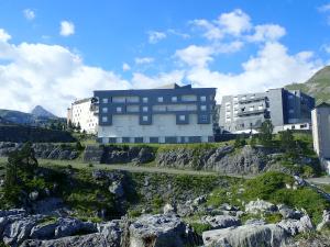 un bâtiment au sommet d'une montagne avec des rochers dans l'établissement Résidence Les Balcons du Pic d'Anie, à Arette
