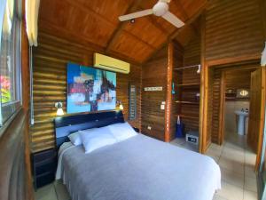a bedroom with a bed and a television at Horizon Hotel & Yoga center in Santa Teresa Beach