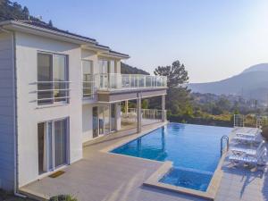 een huis met een zwembad naast een huis bij ORKA Prestige Villa, G in Fethiye