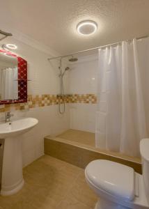 y baño con aseo, lavabo y ducha. en Hotel Raha Tower en Dar es Salaam