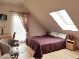 a attic bedroom with a bed and a window at "Trakaitis" apartments in Villa in Trakai