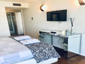 a bedroom with a bed with a desk and a television at Luxury botafoch in Ibiza Town