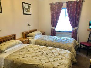 a hotel room with two beds and a window at Atlantic Guest House in Donegal