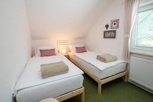 two beds in a small room with a window at Apartmaji Rauter in Bohinj