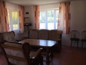 a living room with a table and chairs and windows at Ignatówka in Darłowo