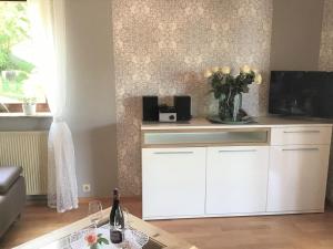 a living room with white cabinets and a vase of flowers at Ferienwohnung Zum Harpelstein in Horath