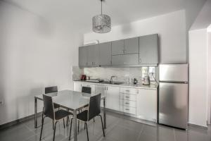 a kitchen with a table and a stainless steel refrigerator at Terra di Meteora Suites #1 in Kalabaka