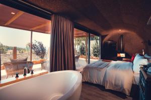 a bathroom with a tub and a bed and a bedroom at Charm Nature in Azoia +37 photos
