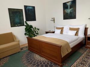 a bedroom with a large bed and a chair at Antik Hotel Sofia in Litomyšl