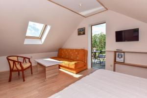 um quarto com uma cama, um sofá e uma televisão em "Trakaitis" nameliai em Trakai