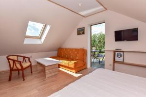 a bedroom with a bed and a couch and a tv at "Trakaitis" nameliai in Trakai