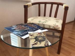 a chair with a glass table with a book on it at Guest House Dijana in Korčula