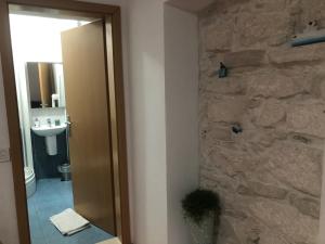 a bathroom with a stone wall and a sink at Guest House Dijana in Korčula
