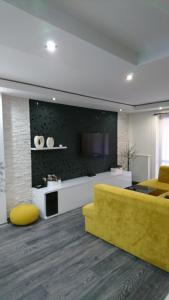 uma sala de estar com um sofá amarelo e uma cozinha em Apartmán Sofia em Veľký Slavkov