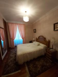 Un dormitorio con una cama grande y una lámpara de araña. en Pension Lorea, en San Sebastián