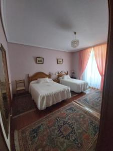 1 dormitorio con 2 camas y alfombra en Pension Lorea, en San Sebastián