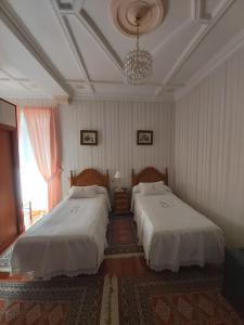 1 dormitorio con 2 camas y lámpara de araña en Pension Lorea, en San Sebastián