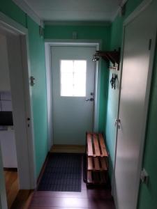 a room with a door and a bench in front of it at Koselig to roms leilighet in Vennesla