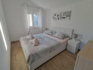 ein Schlafzimmer mit einem Bett mit zwei ausgestopften Tieren darauf in der Unterkunft Apartmani Goga 2 in Molat