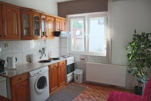 a kitchen with a washing machine and a window at Sobe-Apartmani Modriča in Modriča