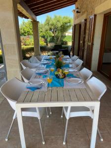 a long white table with white chairs around it at Finca Santa Maria in Alcudia