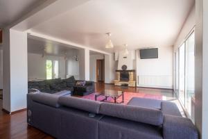 Una sala de estar con un sofá y un televisor. en Villa Auba Lloret, en Lloret de Mar