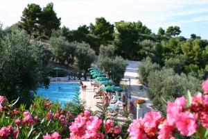 a resort with a pool with umbrellas and people swimming at Residence Chiesiola in Vieste