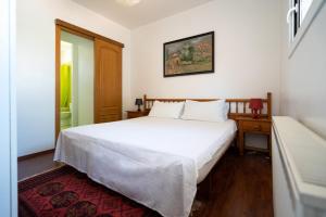 Un dormitorio con una gran cama blanca y una mesa en Villa Auba Lloret, en Lloret de Mar