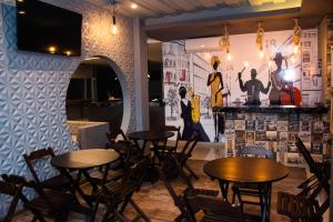 a restaurant with tables and chairs and a wall with a mural at INACIO'S PLAZA HOTEL in Marabá