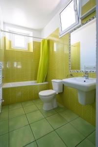 a green bathroom with a toilet and a sink at Villa Auba Lloret in Lloret de Mar