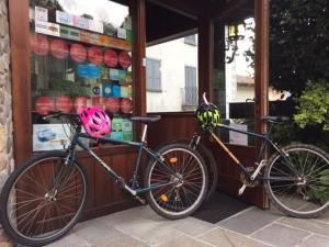 twee fietsen geparkeerd voor een winkelraam bij Da Gigi in Margno