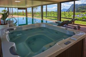 a large bath tub in a room with a pool at Hotel Quinta Do Furao in Santana