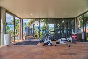 a gym with cardio equipment in a building with windows at Hotel Quinta Do Furao in Santana